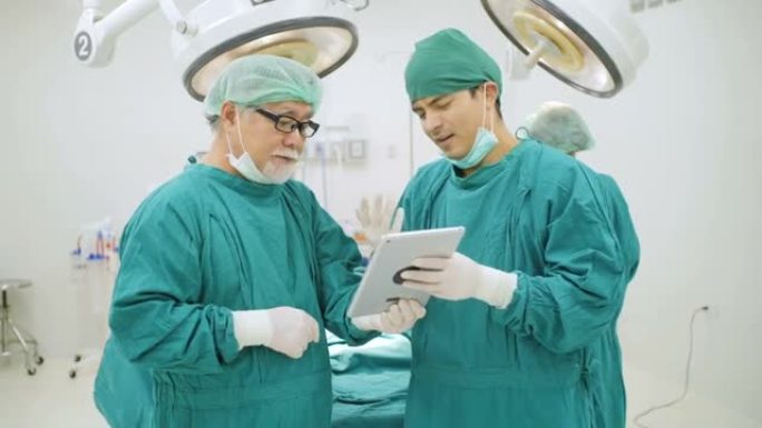 两名外科医生在医院手术室使用数字平板电脑读取患者的病史。