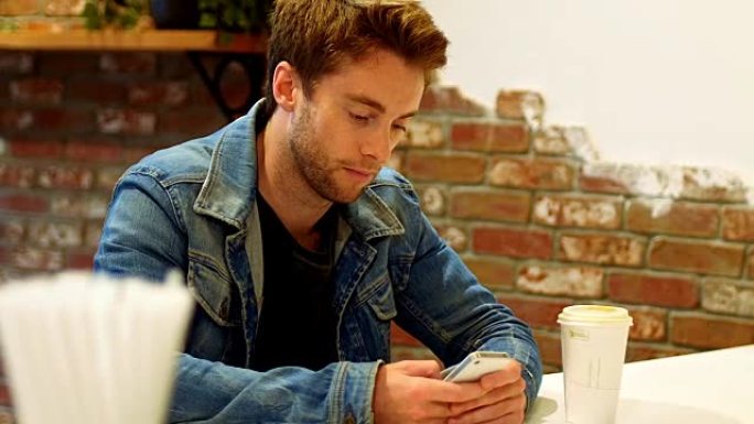 男子在餐桌上使用手机