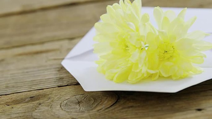 木板上信封中的黄色花朵