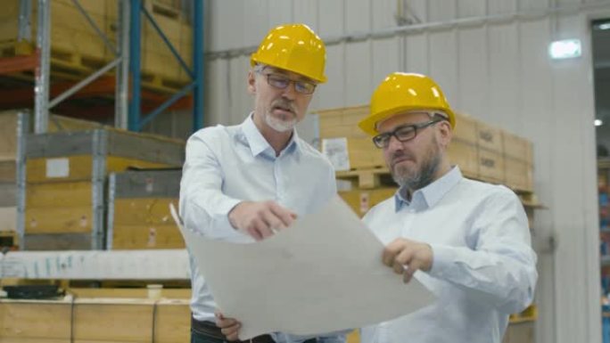 物流中心仓库的两名员工在白皮书上谈论该计划。
