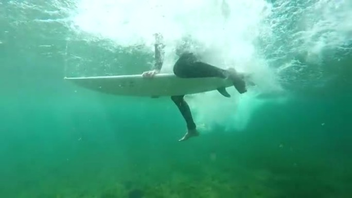 水下慢动作: 冲浪者在清澈的大西洋中划桨