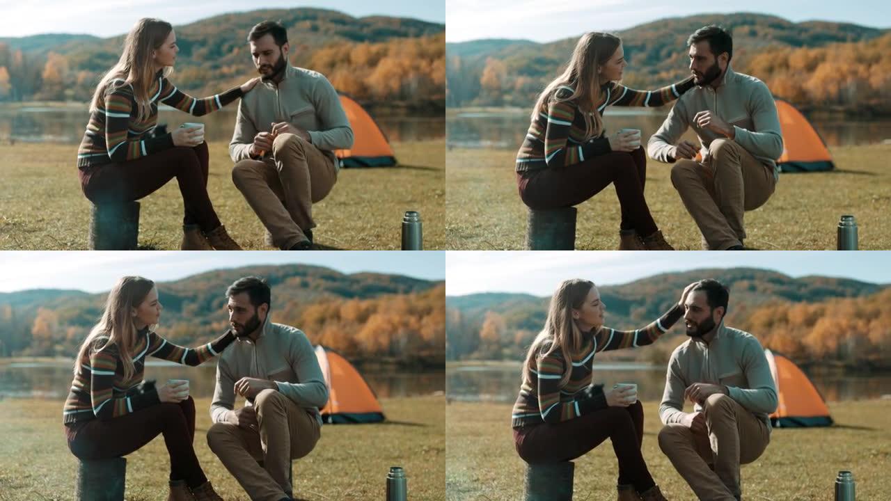 男人和女人在湖边露营时喝咖啡