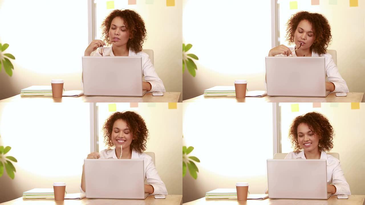 微笑的休闲女商人使用笔记本电脑