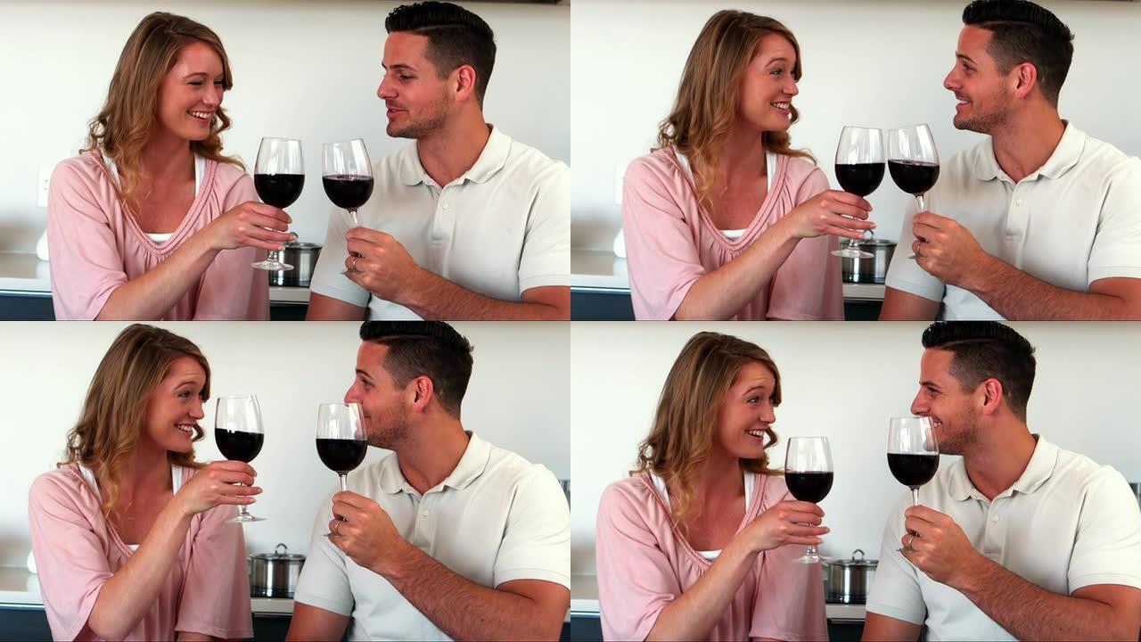 幸福的夫妇在厨房里喝红酒