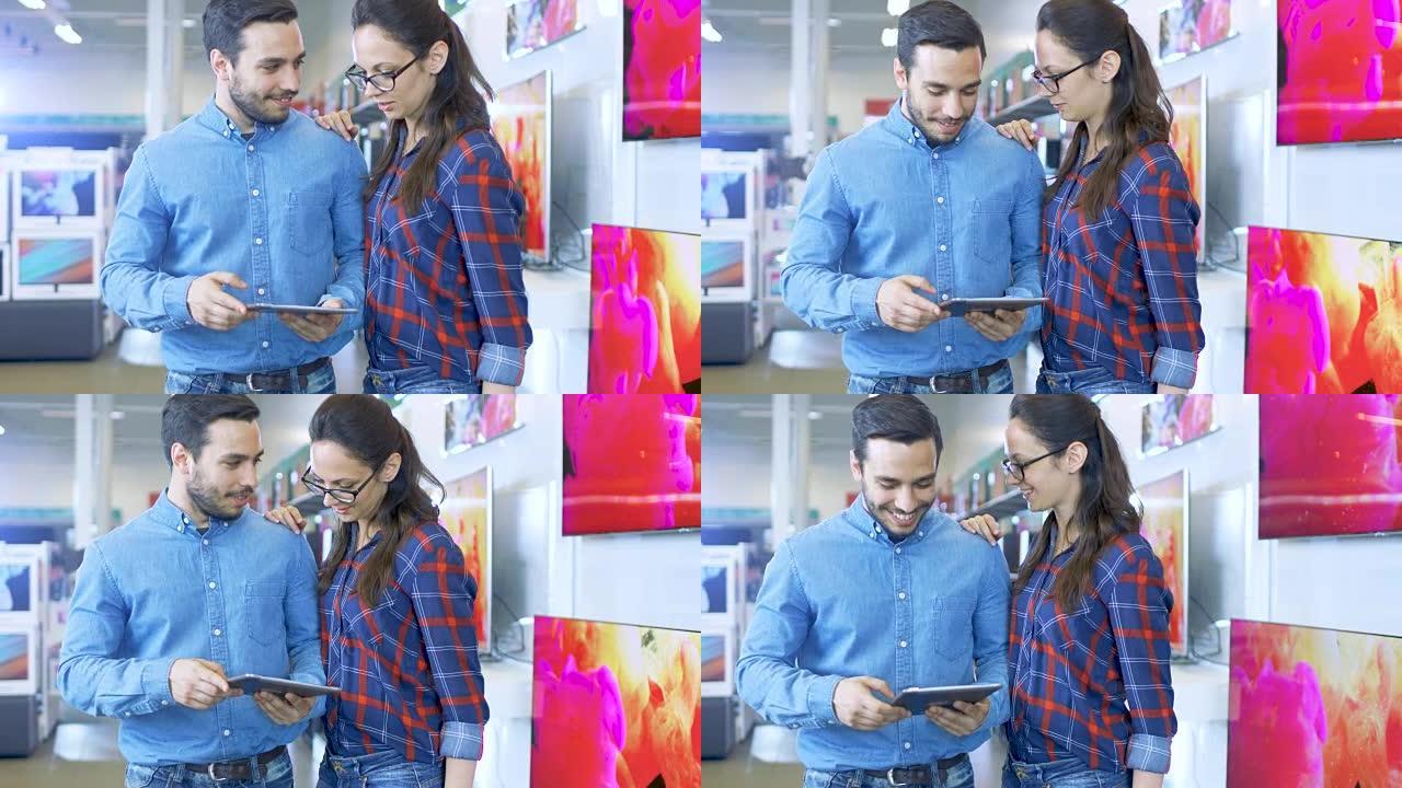 电子商店里的年轻美丽夫妇正在寻找最新的平板电脑型号，为他们的使用和预算选择合适的型号。商店明亮而现代