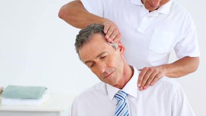物理治疗师为商人提供颈部按摩