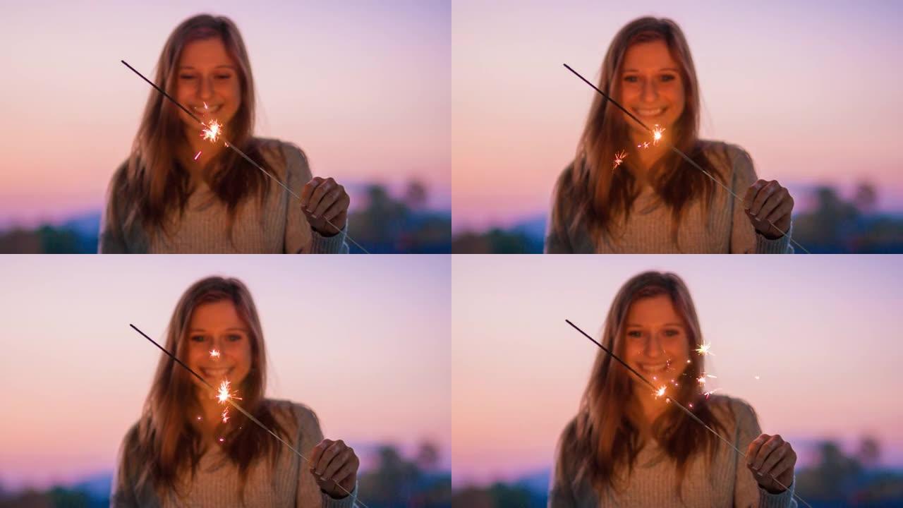 快乐的年轻女子在黄昏时用烟火庆祝