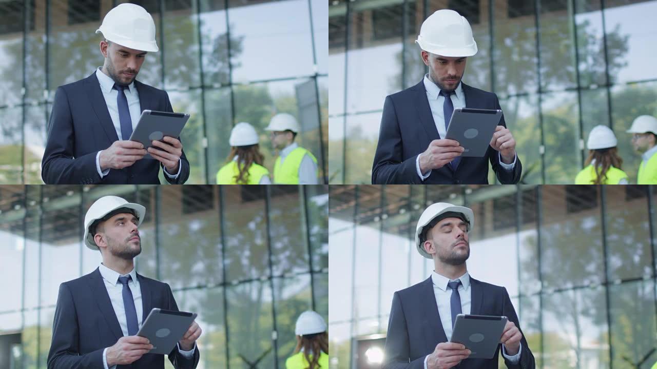 穿着安全帽走路、说话和使用平板电脑的商人。背景上正在建造的玻璃建筑或摩天大楼。