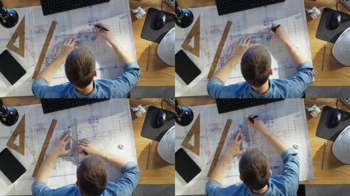 一位技术工程师在绘制蓝图，利用计划的俯视图。各种各样的绘画对象躺在他的桌子上。