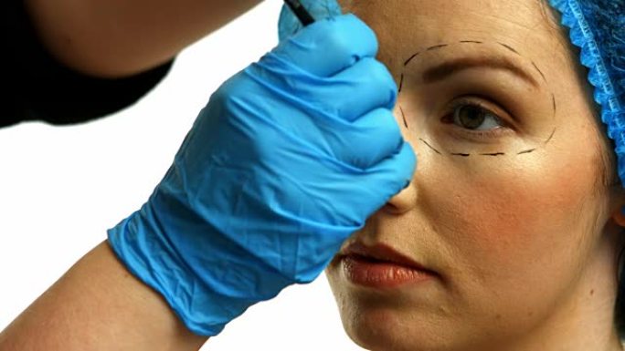 整形外科医生在女人脸上做标记