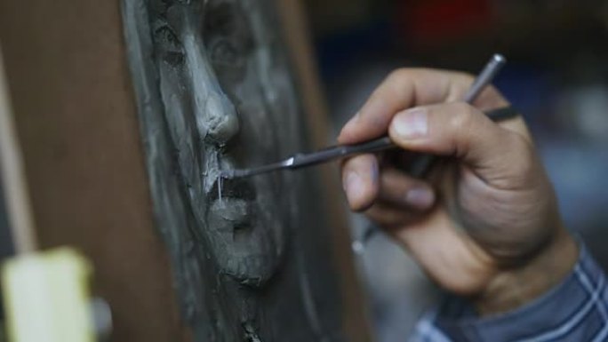 雕塑家在艺术工作室的画布上创作人脸雕塑的特写