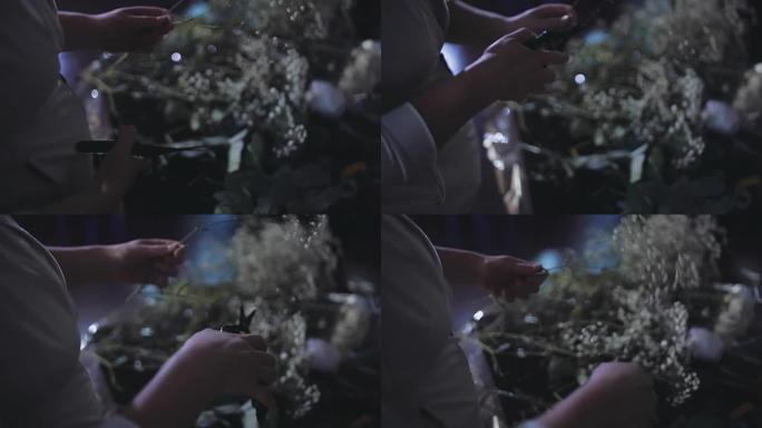 女性手剪花的特写镜头。有剪枝的花店用白色的花朵做花束
