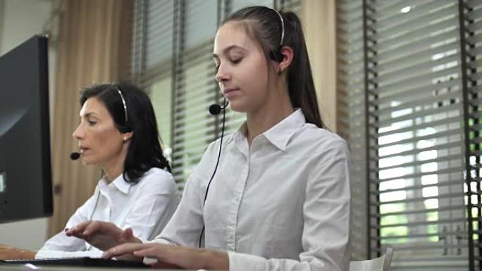 客户支持电话接线员在呼叫中心的办公桌上工作