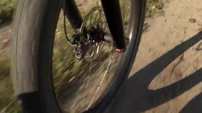 特写: 电动越野自行车轮胎车轮在砾石路径上快速旋转