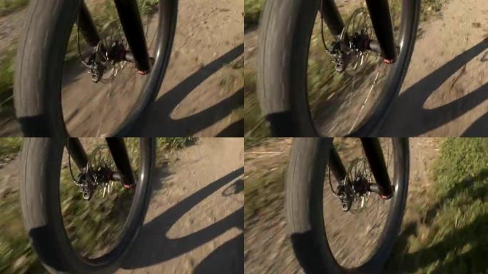 特写: 电动越野自行车轮胎车轮在砾石路径上快速旋转