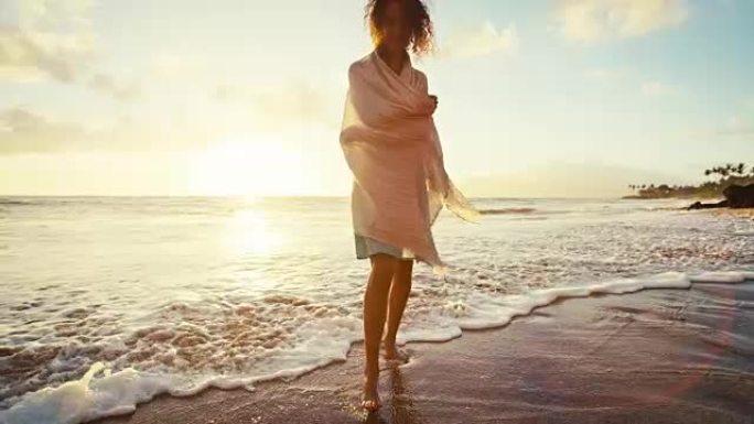 美丽的年轻女子在沙滩上慢动作行走，柔和温暖的复古色调