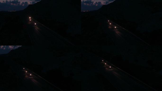 夜间在高速公路上驾驶摩托车的摩托车手的无人机视图