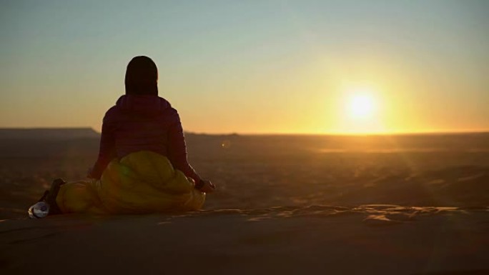 在沙漠日落前沉思的女人