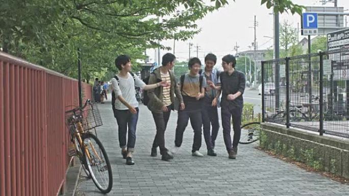 欢快的日本大学生在京都的人行道上行走