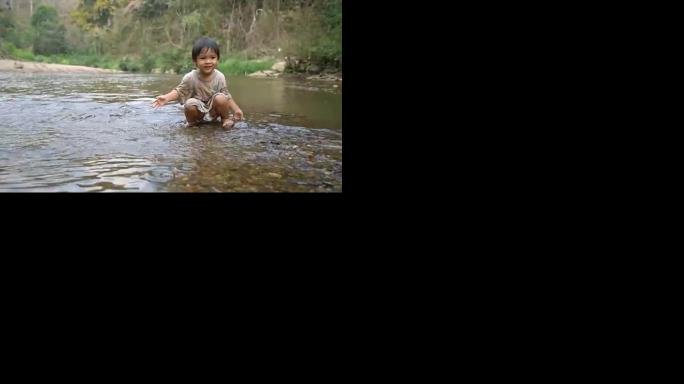 小男孩在小溪里玩水。
