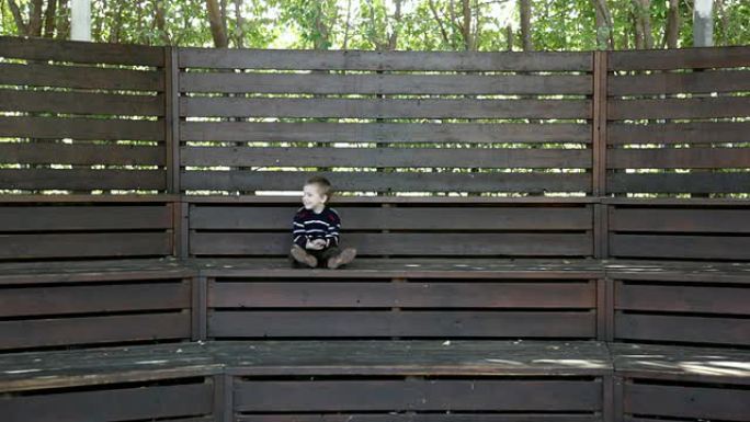 小男孩坐在木楼梯上