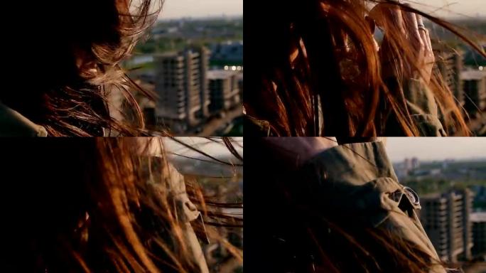 风吹起长长的黑发。女孩低着头站在屋顶上拉直了头发。特写。慢动作