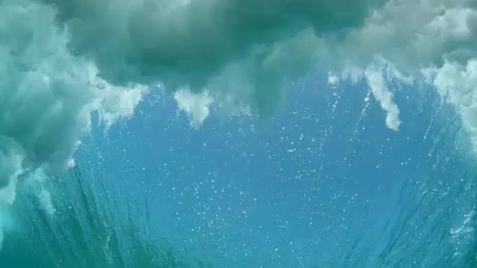 水下: 经验丰富的冲浪者在阳光明媚的斐济雕刻出巨大的破浪