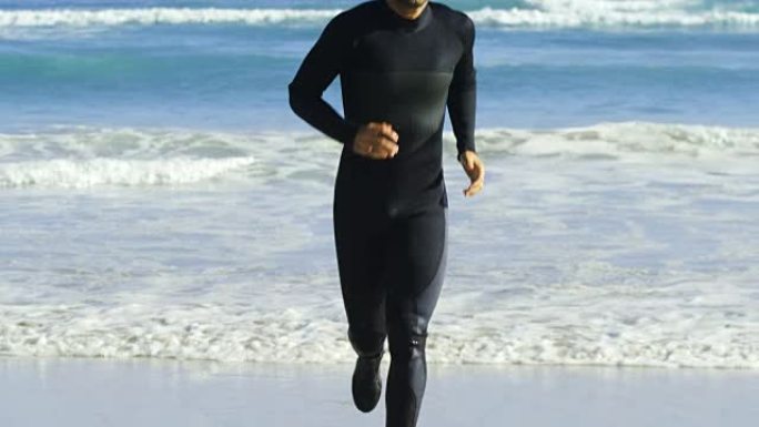 男性冲浪者在海滩上跑步
