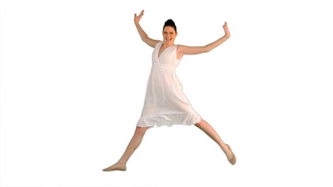 穿着白色连衣裙跳跃的开朗年轻女子