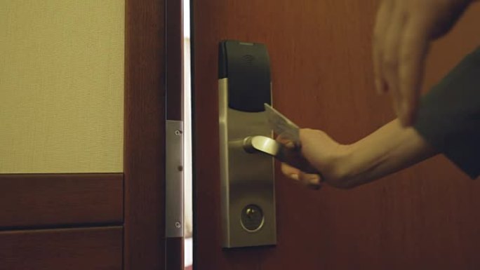 穿着西装的女商人的特写镜头使用非接触式钥匙卡打开酒店房间门并进入房间。旅游、商务和人的概念