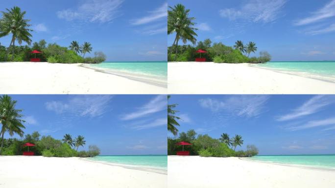 马尔代夫异国情调的白色海滩上有遮阳的红色躺椅