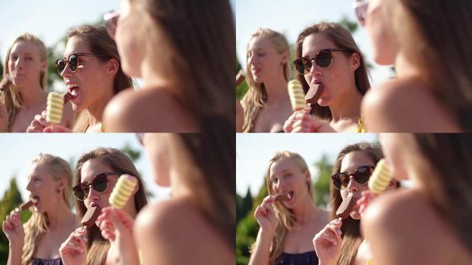 十几岁的女孩朋友在游泳池旁笑着冰淇淋