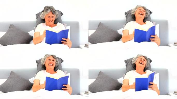 年长的女人在床上看书