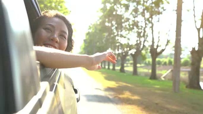 年轻的亚洲女性喜欢透过车窗感受风。