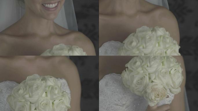 美丽的新娘拿着一束玫瑰花笑着