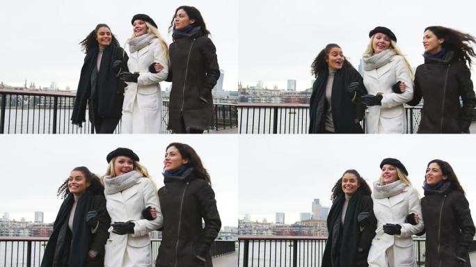 女性朋友在冬季访问伦敦时沿着南岸散步