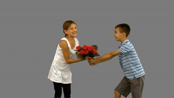 男孩向一个小女孩献上一束鲜花