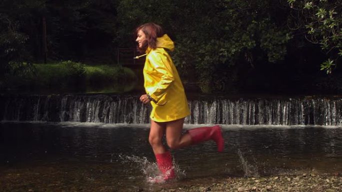 穿着黄色雨衣的女人在水中奔跑
