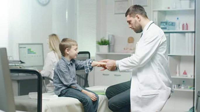医生检查小男孩的手是否有受伤的迹象。