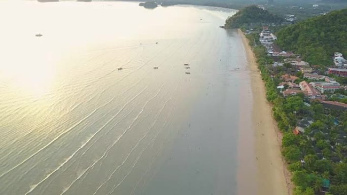 空中: 在海滨度假胜地上空飞行，人们沿着海滩散步。