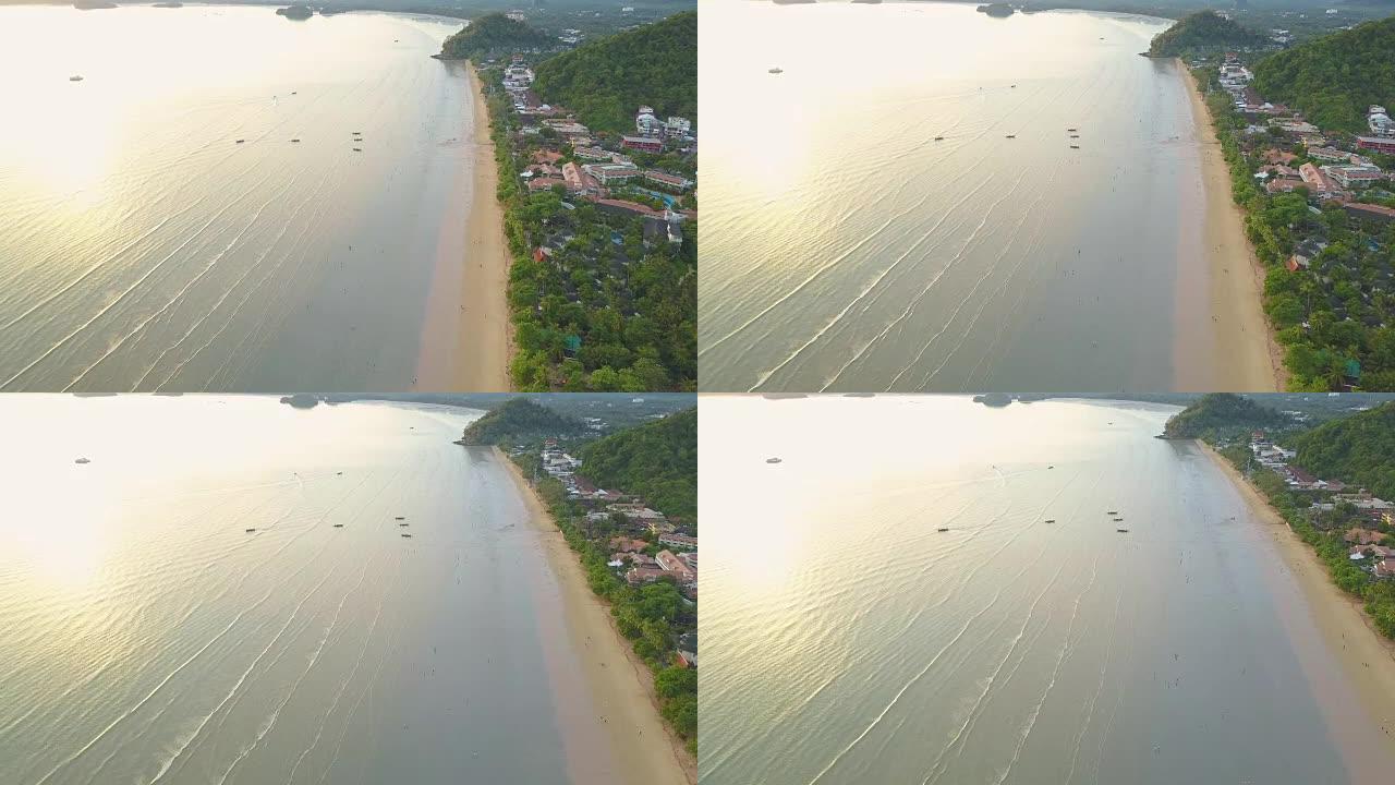 空中: 在海滨度假胜地上空飞行，人们沿着海滩散步。