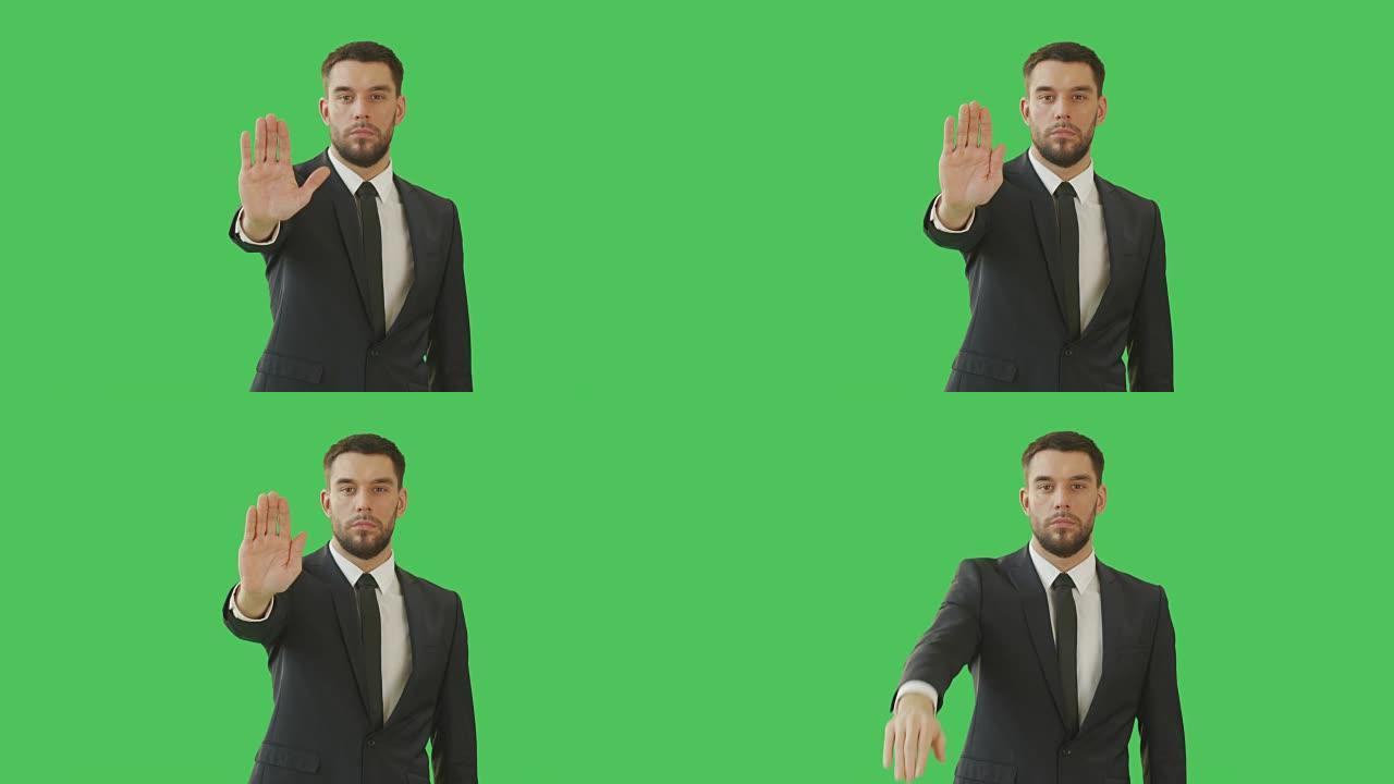 一个严肃的商人用手做停止手势的中景。以绿屏背景拍摄。