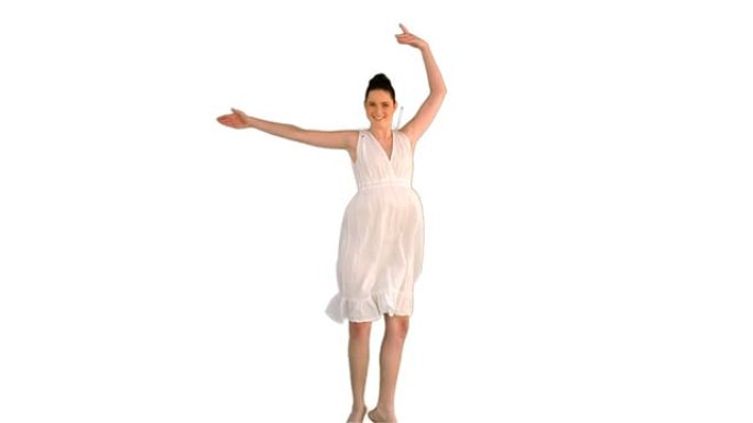 穿着白色连衣裙跳跃的美丽年轻模特