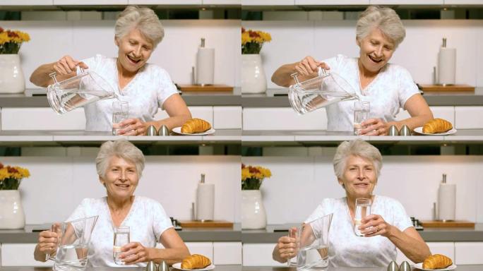 老年妇女倒一杯水作为早餐