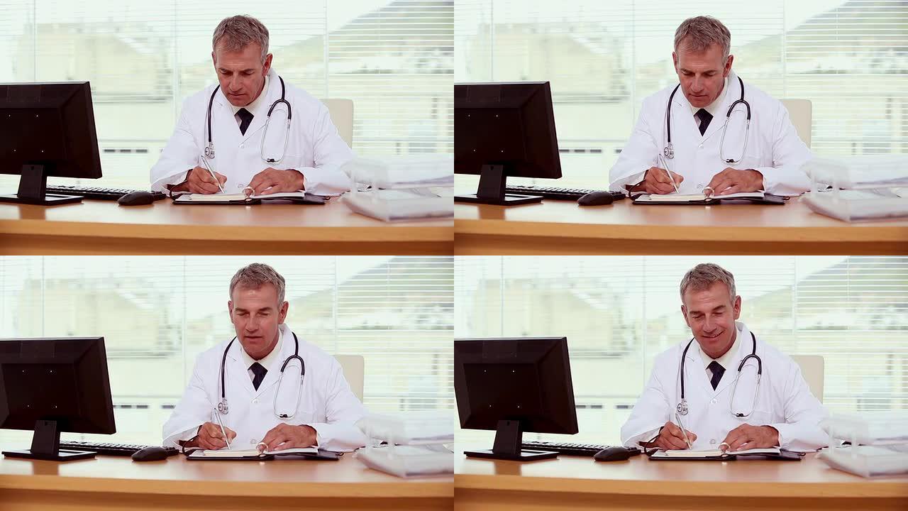 微笑的医生在笔记本上写字