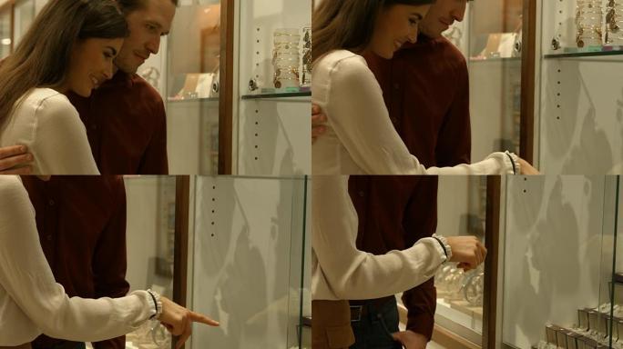 情侣在橱窗购物中指向珠宝