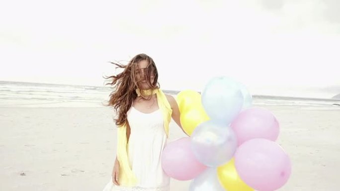 海滩上有彩色气球的女孩