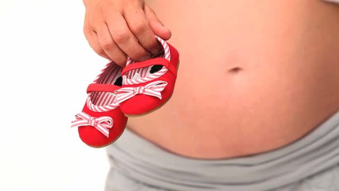 孕妇抱着未来婴儿的鞋子