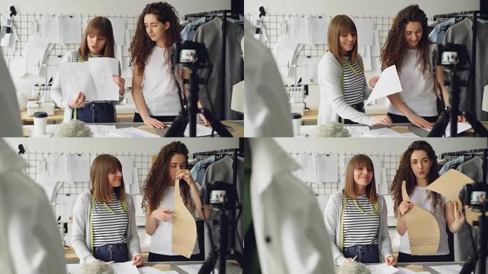 年轻漂亮的女性时装设计师博客作者正在用相机录制有关缝制新衣服的视频。女孩们正在展示草图和模板，并在一