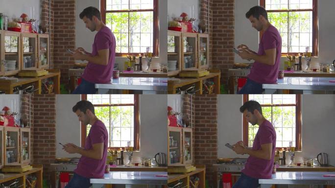年轻人站在厨房里使用平板电脑，在R3D上拍摄